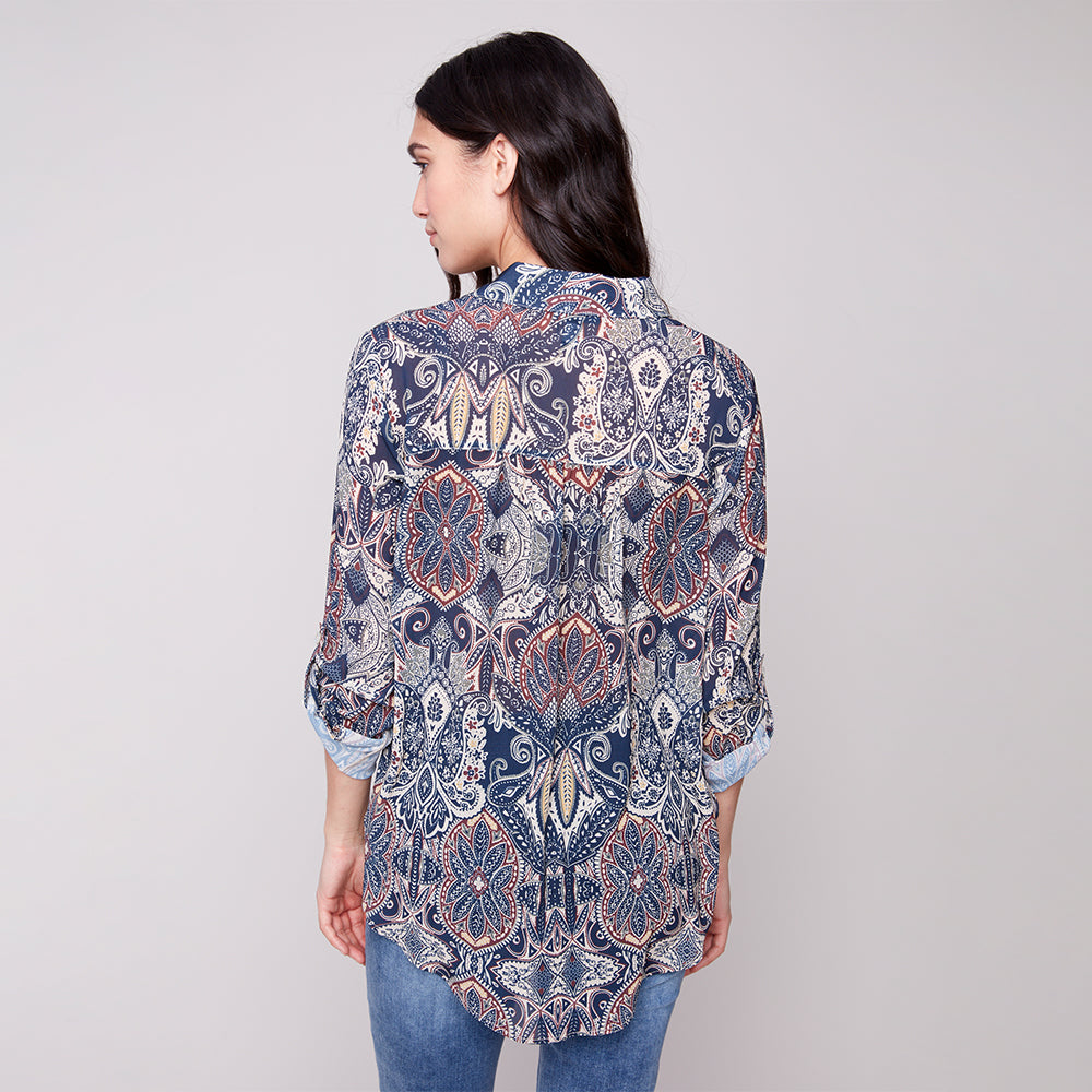 Woman wearing a patterned shirt on a plain background