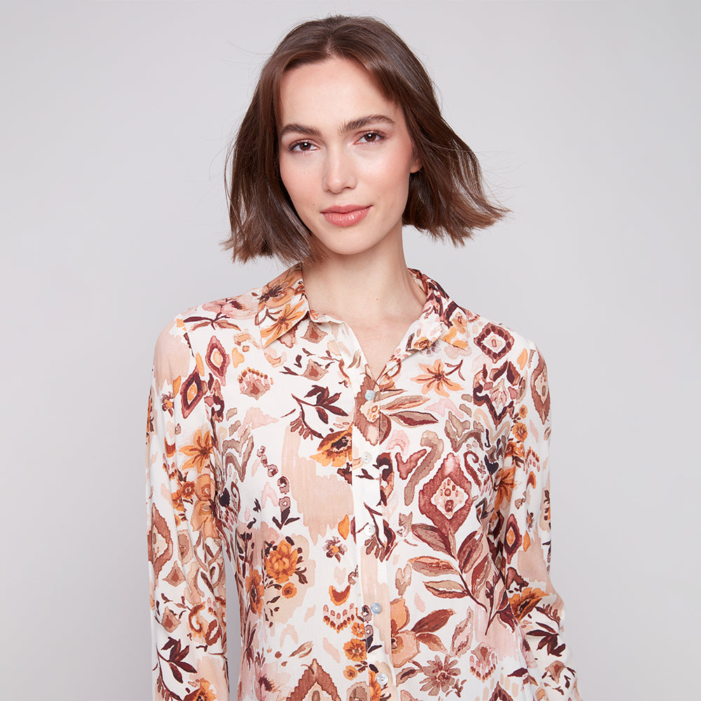 Woman wearing a floral blouse against a plain background