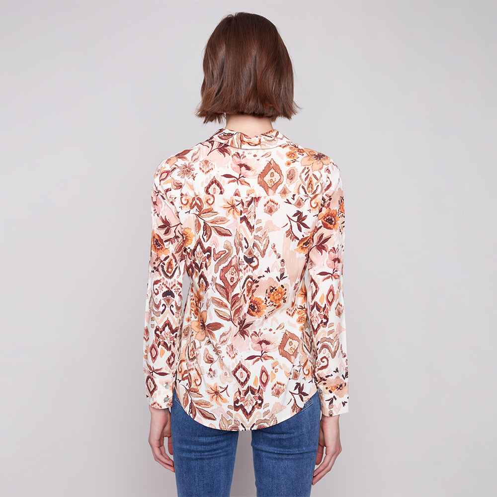 Woman wearing a floral blouse with a plain background