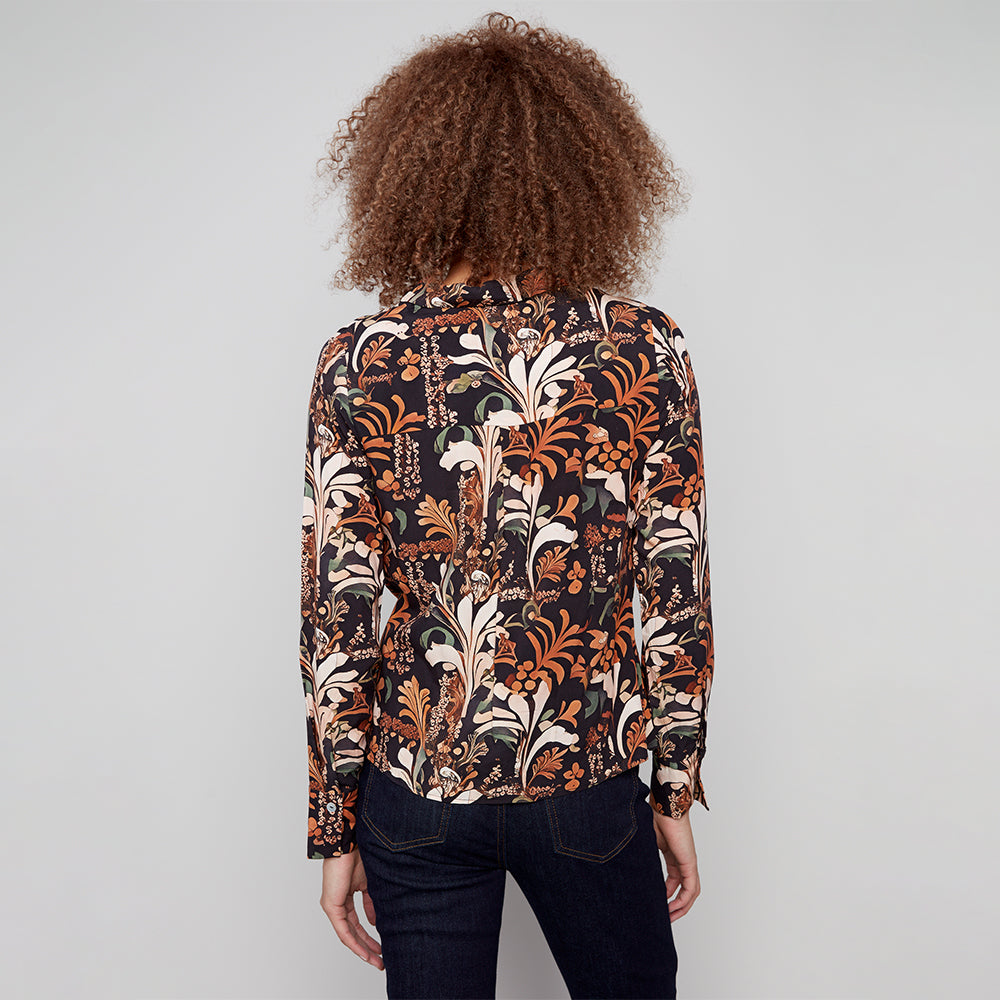 Person wearing a patterned shirt with a plain background