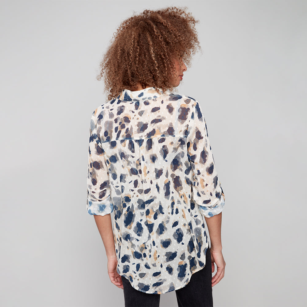 Person wearing a patterned shirt against a plain background