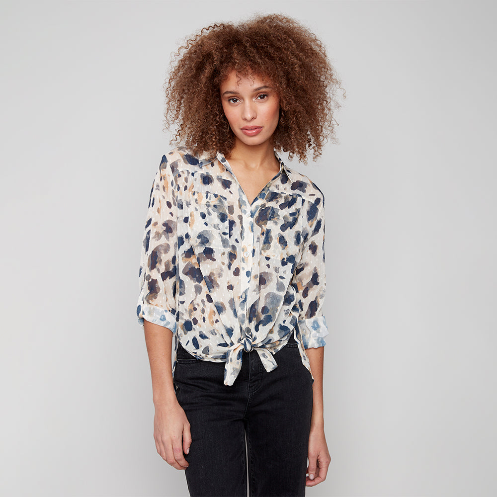 Woman wearing a patterned blouse with a plain background