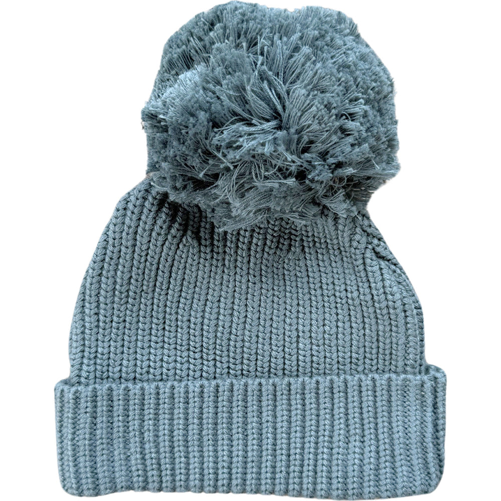 Blue knit beanie with a textured pom-pom on a white background