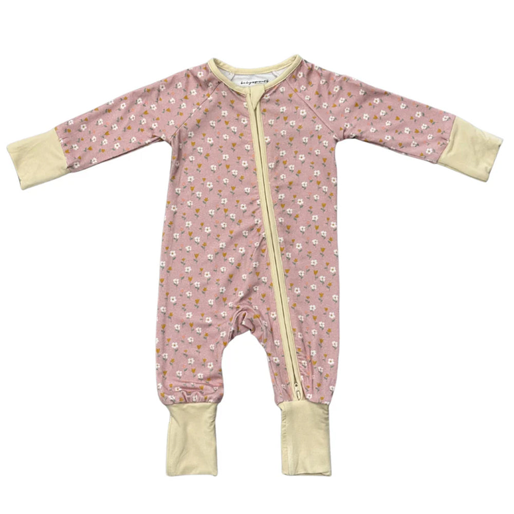 Pink baby onesie with floral pattern and yellow zipper on a white background