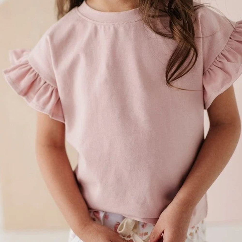 Pink blouse with ruffled sleeves worn by a child on a plain background
