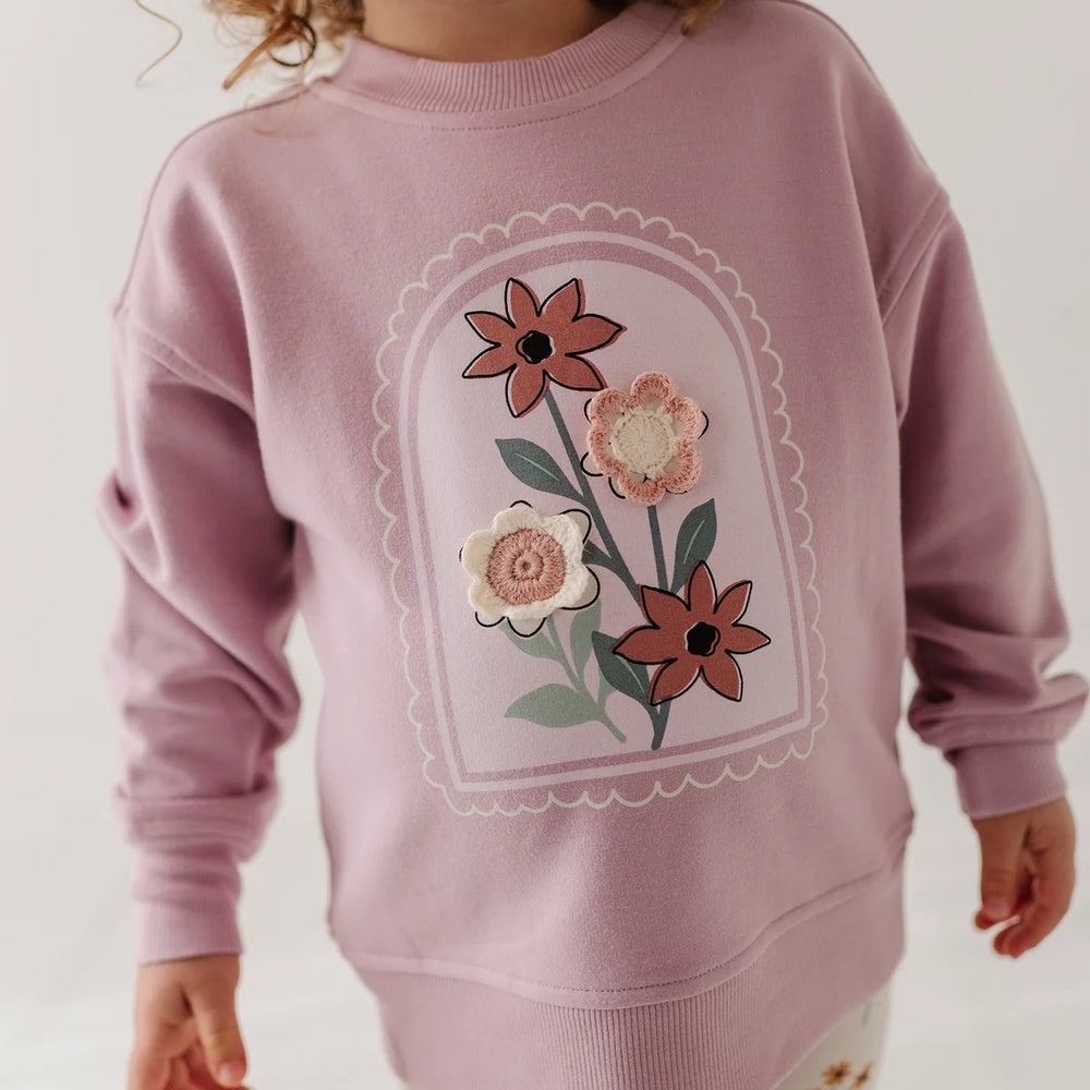 little girl in pink sweatshirt with flowers on front