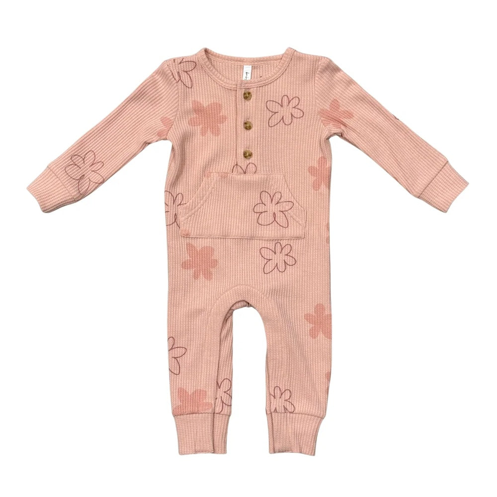 A baby's long-sleeve ribbed jumpsuit in a dusty pink color, decorated with a pattern of simple pink and brown flower outlines. It features a button-up front with three wooden buttons.