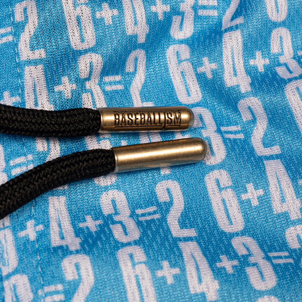 Close-up of black braided drawstring cords threaded through metallic gold eyelets engraved with the word 'BASEBALLISM', set against a blue fabric background patterned with white math equations.