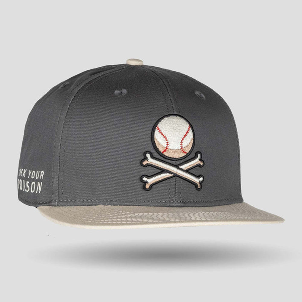 A dark gray snapback baseball cap with a beige flat brim, featuring an embroidered baseball and crossbones patch on the front and white text on the side, shown against a light gray background.