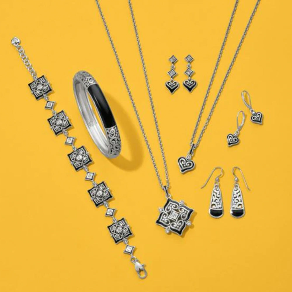 Jewelry set including necklace, bracelet, and earrings on a yellow background