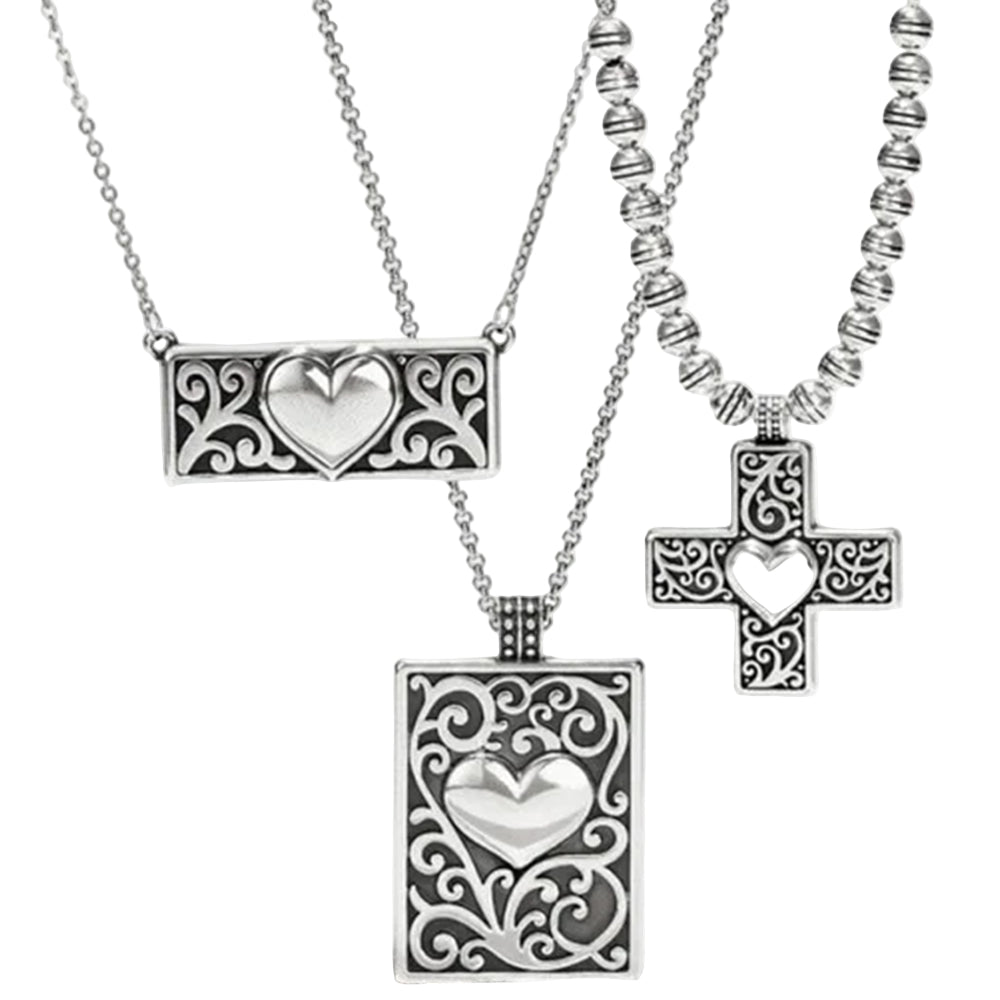 Silver jewelry set with heart and cross pendants on a white background