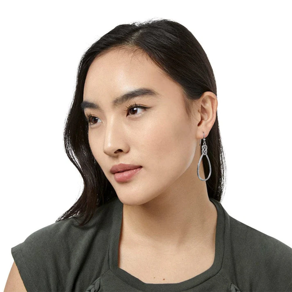 Woman wearing a dark green top with a plain background