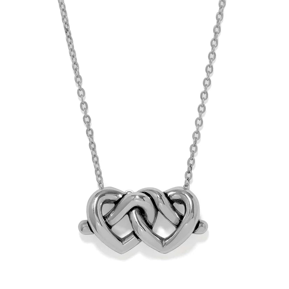 A silver necklace featuring a polished pendant made of two interlocking hearts, suspended from a delicate silver chain against a plain white background.