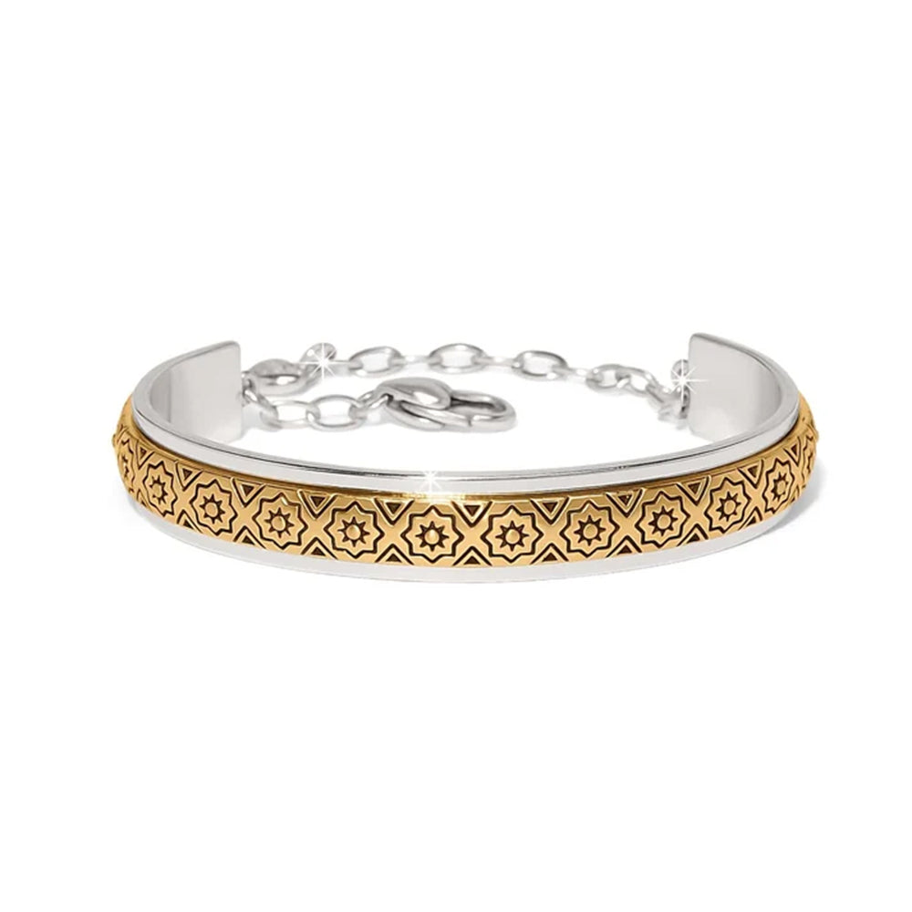 Silver and gold bracelet with intricate design on a white background