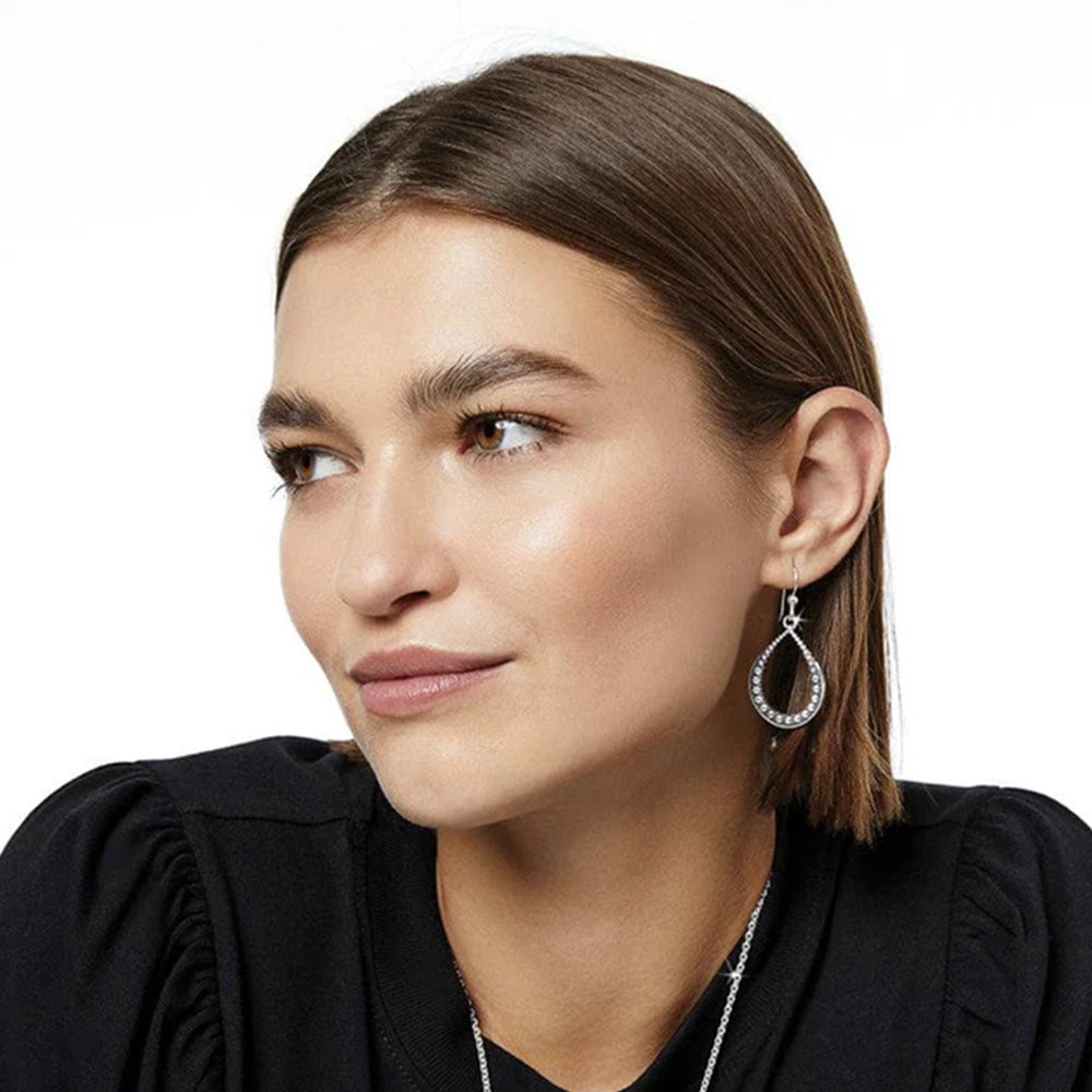 Close-up of a woman wearing a silver earring on a white background