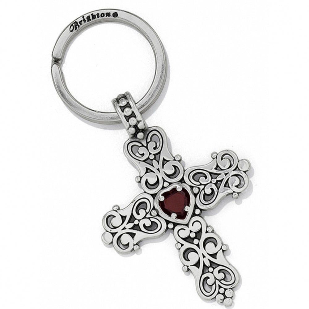 Silver cross keychain with red stone on a white background