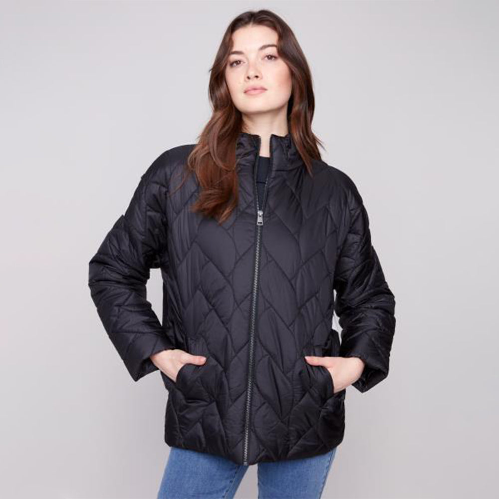 Woman wearing a black quilted jacket on a gray background