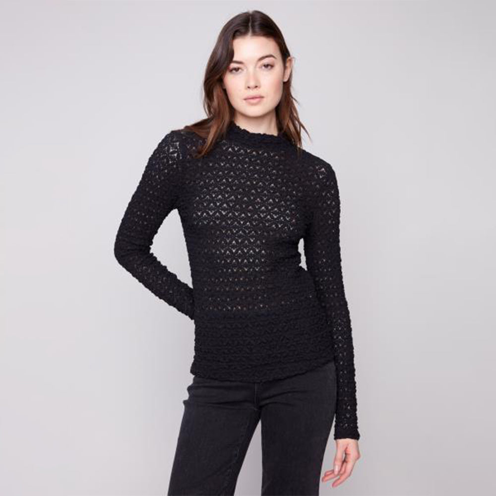 Woman wearing a black textured sweater against a plain background