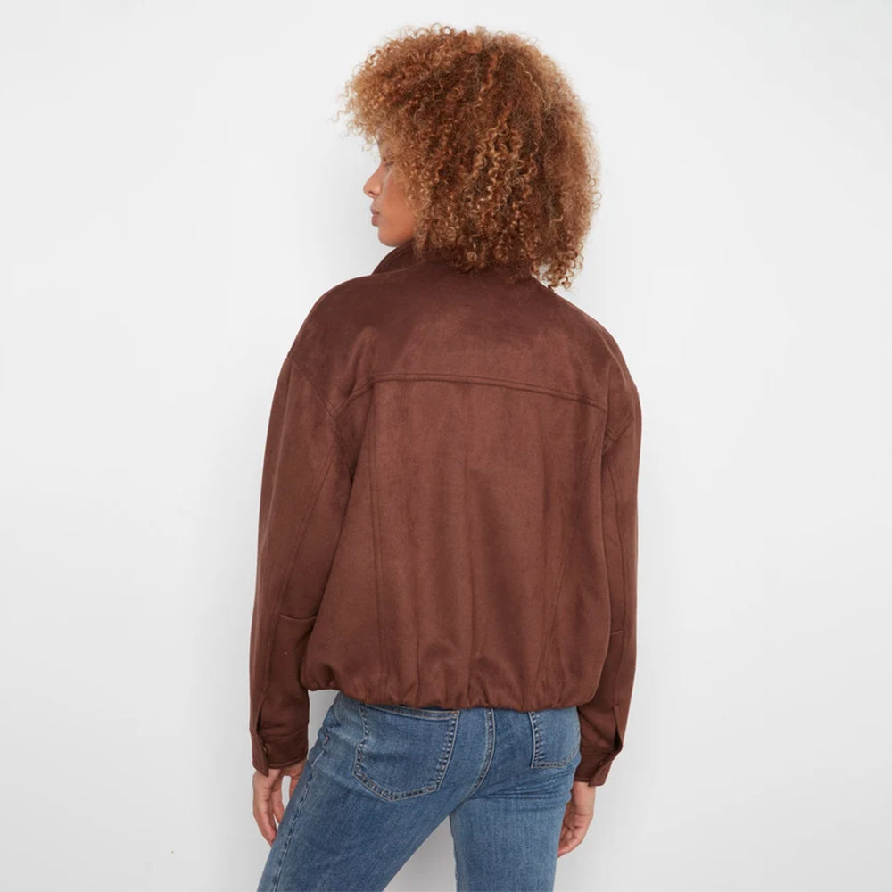 A person shown from the back wearing a brown suede-like jacket and blue jeans against a plain white studio background.