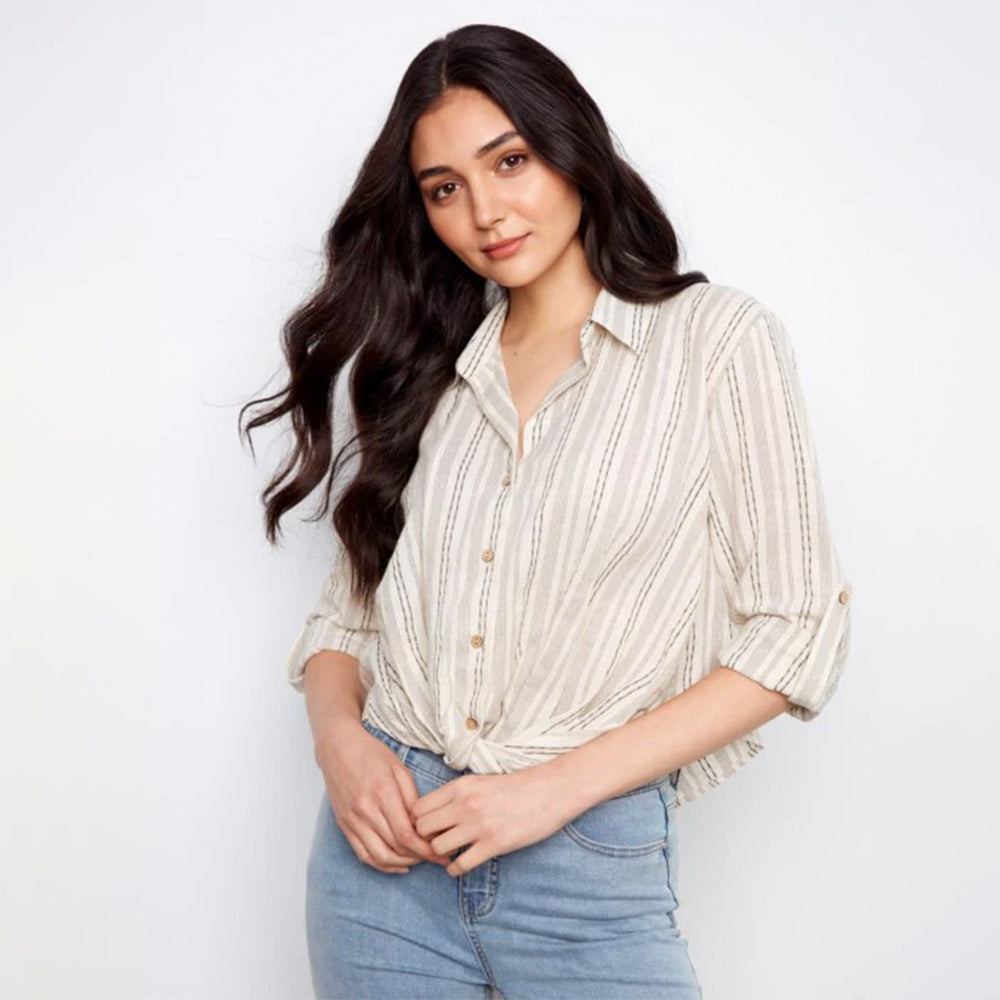 Woman wearing a striped shirt and jeans against a white background