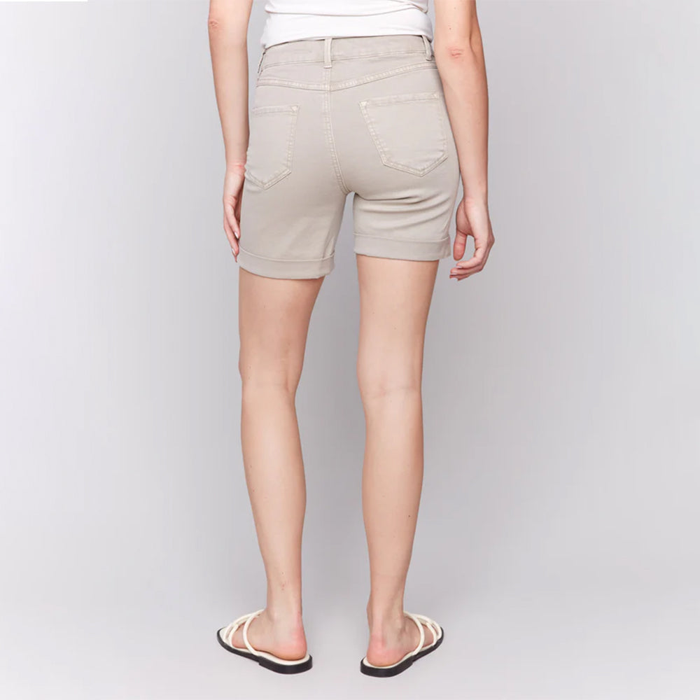 Person wearing beige shorts on a plain background
