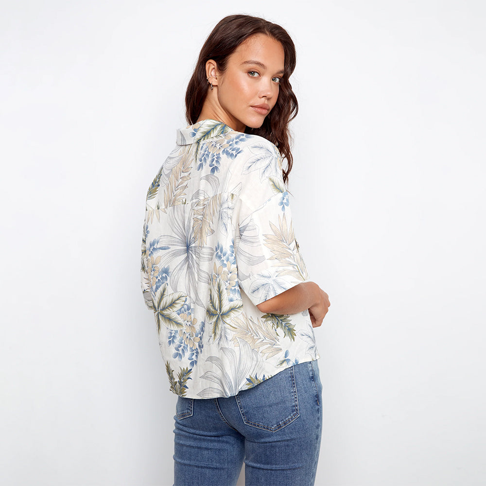 Woman wearing a floral blouse and jeans on a white background