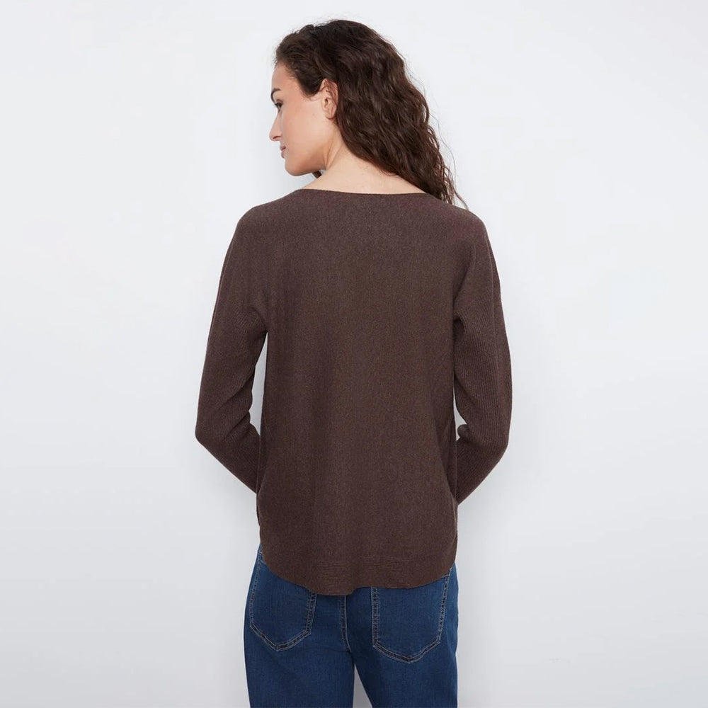 A woman shown from the back wearing a dark brown long-sleeve knit top and blue jeans against a plain white background.