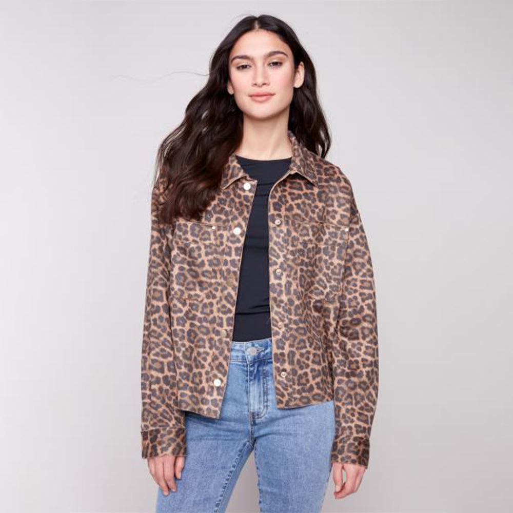 Woman wearing a leopard print jacket and blue jeans on a plain background