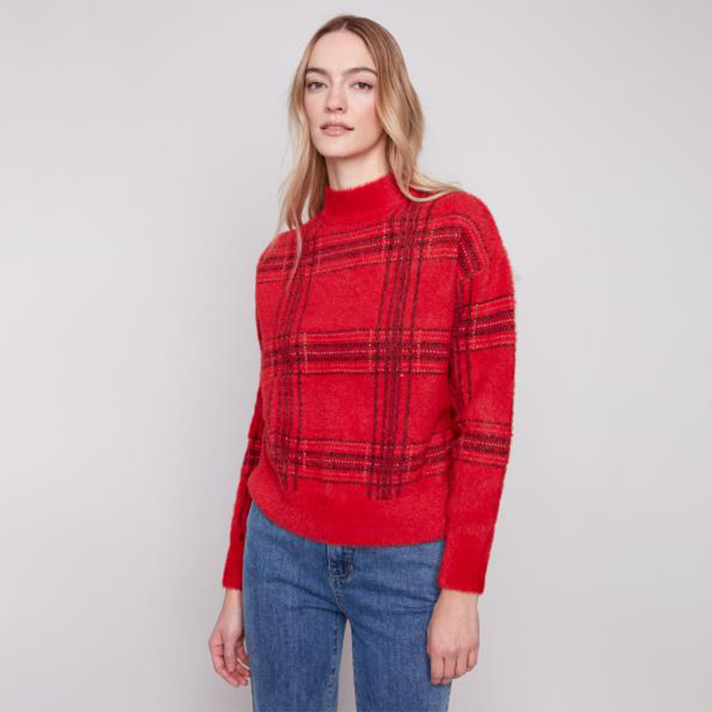 Woman wearing a red plaid sweater and blue jeans on a white background