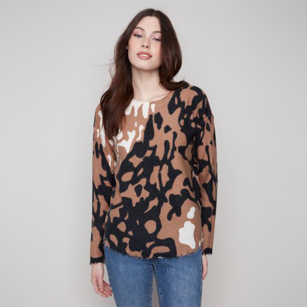 Woman wearing a brown camouflage sweater against a plain background