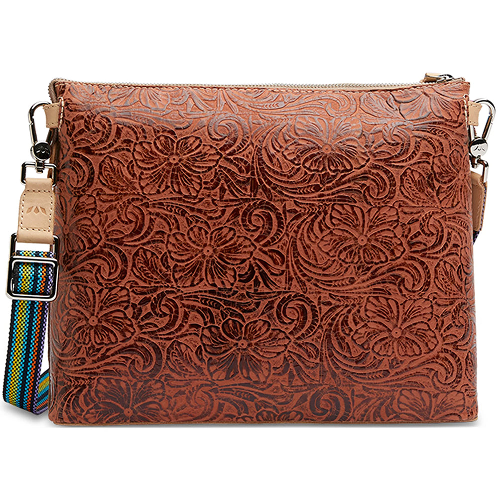 Brown leather clutch with floral patterns and a colorful strap on a white background