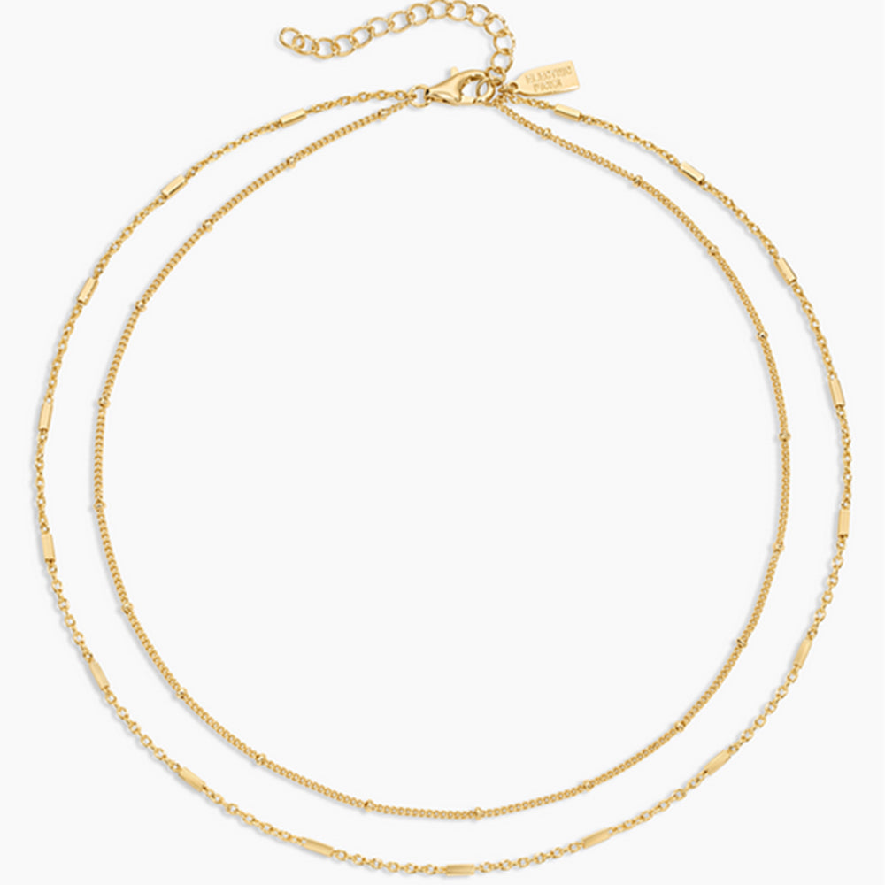 Two gold necklaces on a white background