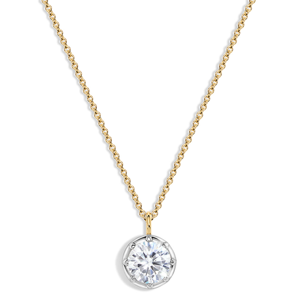 A delicate gold chain necklace with a round bezel-set clear gemstone pendant on a white background.
