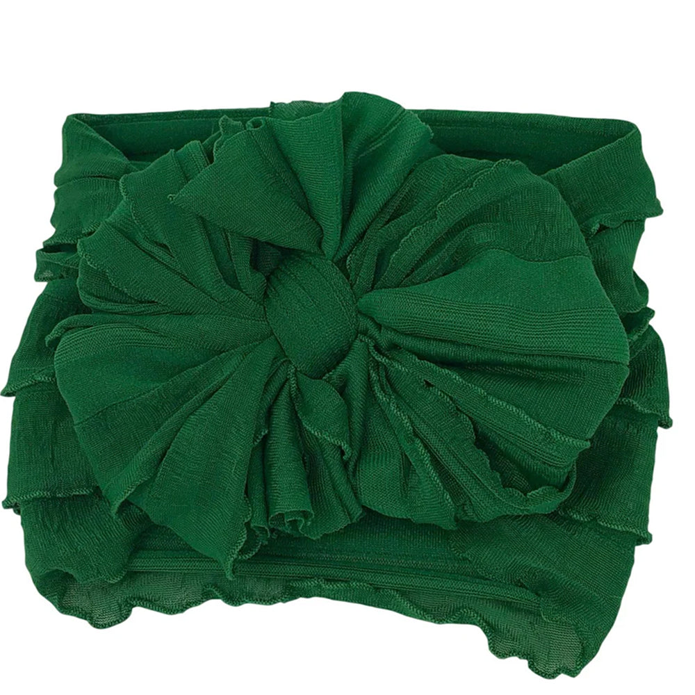 Green headband with a large bow on a white background