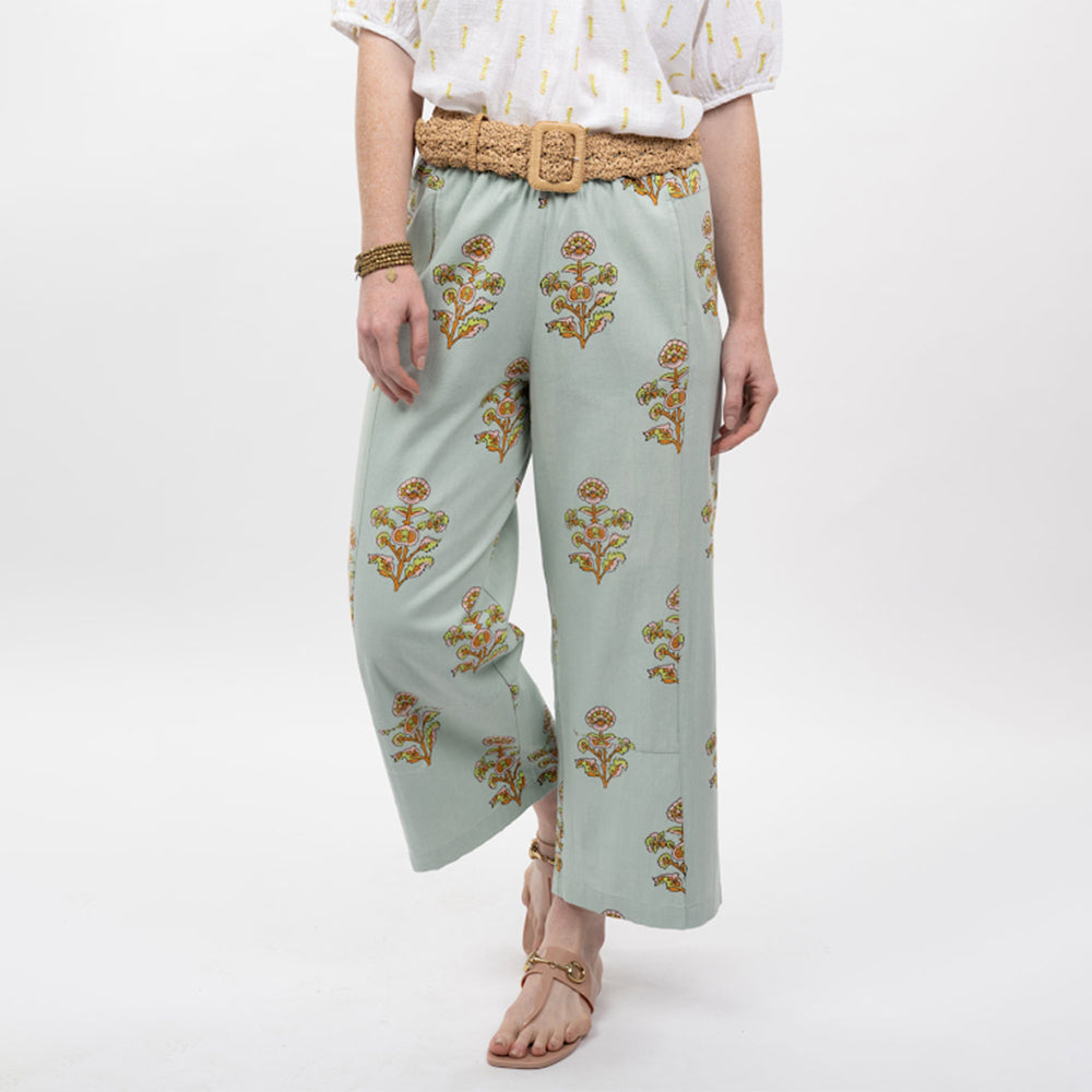Light blue pants with floral patterns worn by a person on a white background