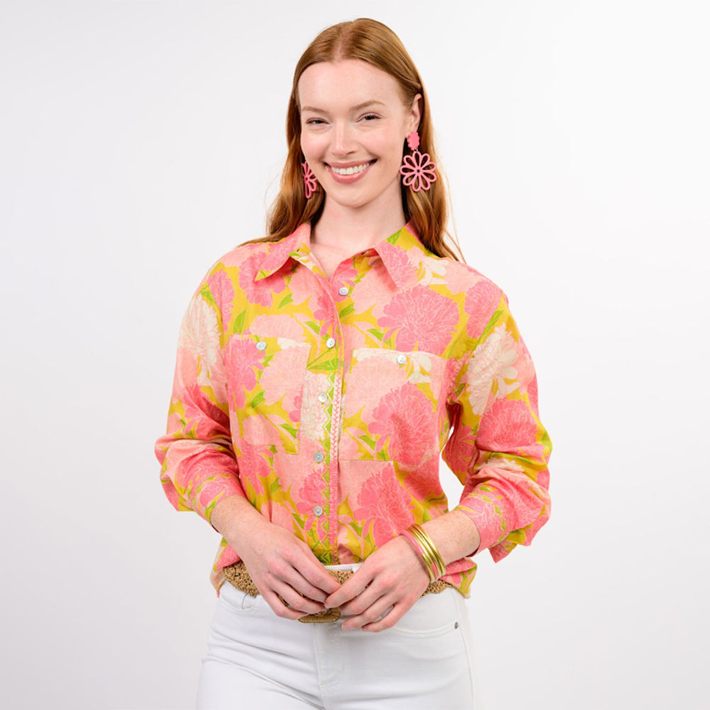 Woman wearing a pink floral blouse with a plain background