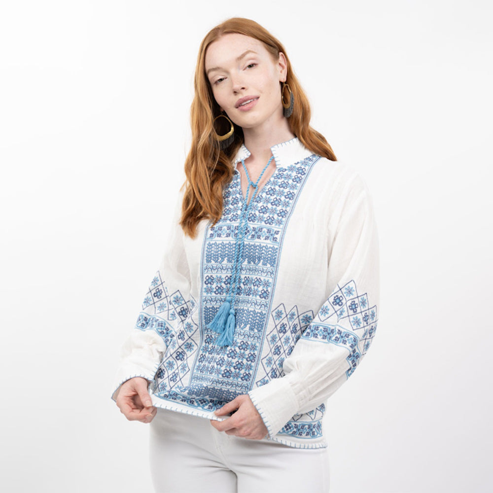 Woman wearing a white and blue patterned jacket on a white background