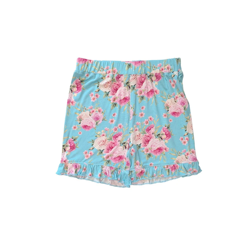 A pair of girls' shorts featuring a light blue background with a pink and white floral print, complete with a ruffled hem and elastic waistband.