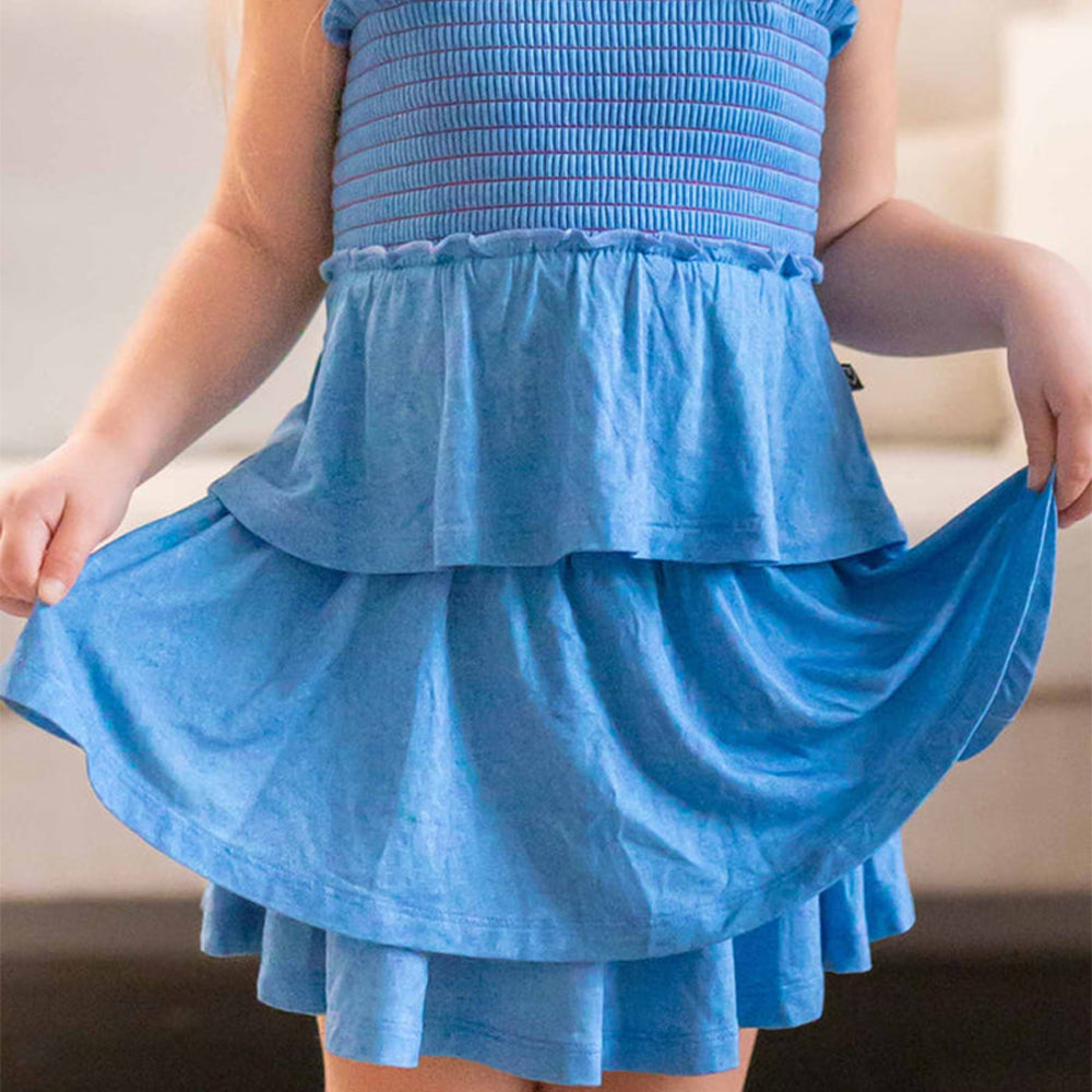 Blue dress with ruffled layers being held by a person.