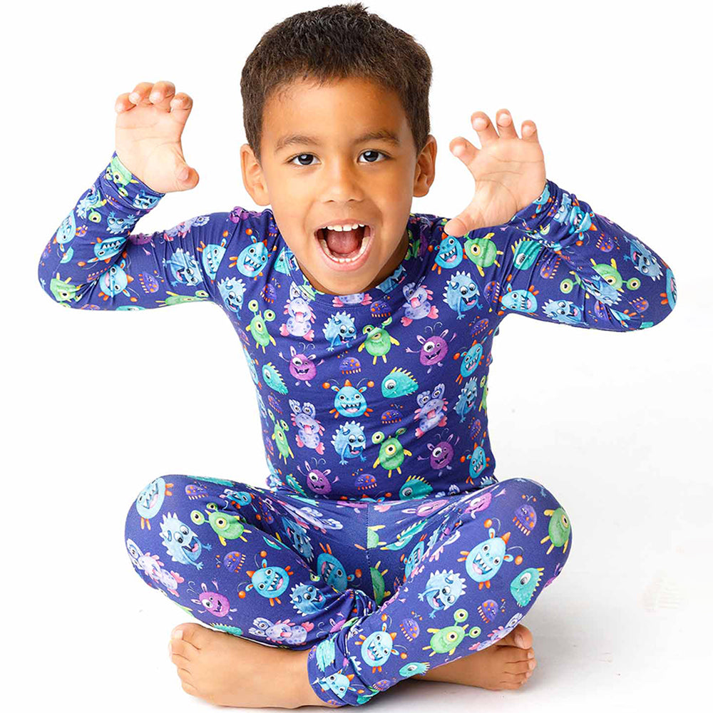 Child wearing a colorful monster-themed outfit on a white background