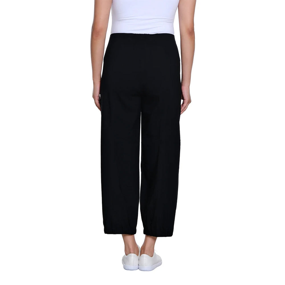 A model shown from the back wearing black wide-leg cropped pants, a white ribbed tank top, and white slip-on sneakers against a plain white background.