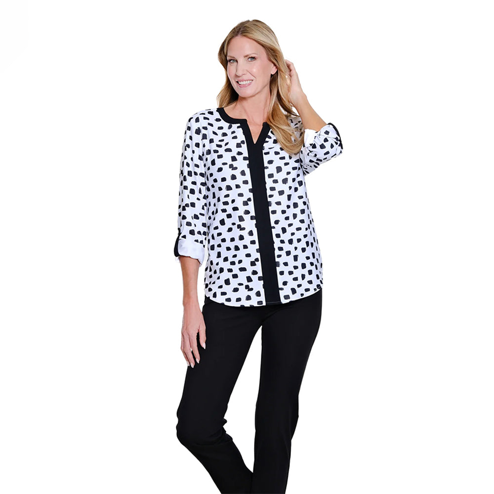 Woman wearing a black and white polka dot blouse with a black accent on a white background