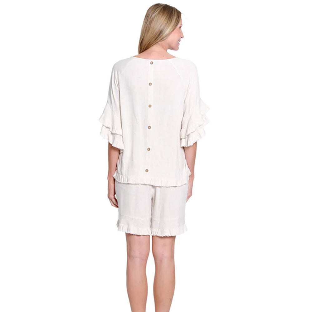 Woman wearing a white outfit with a top and shorts on a white background