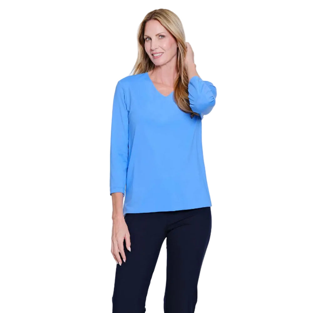Woman wearing a blue long-sleeve top and black pants on a white background