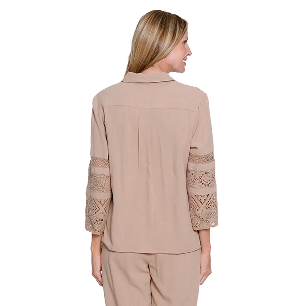 Woman wearing a beige blouse with lace sleeves on a white background