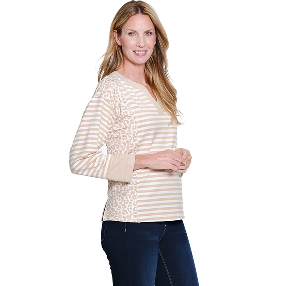 Woman wearing a cream and beige striped long-sleeve top with a leopard print accent on a white background