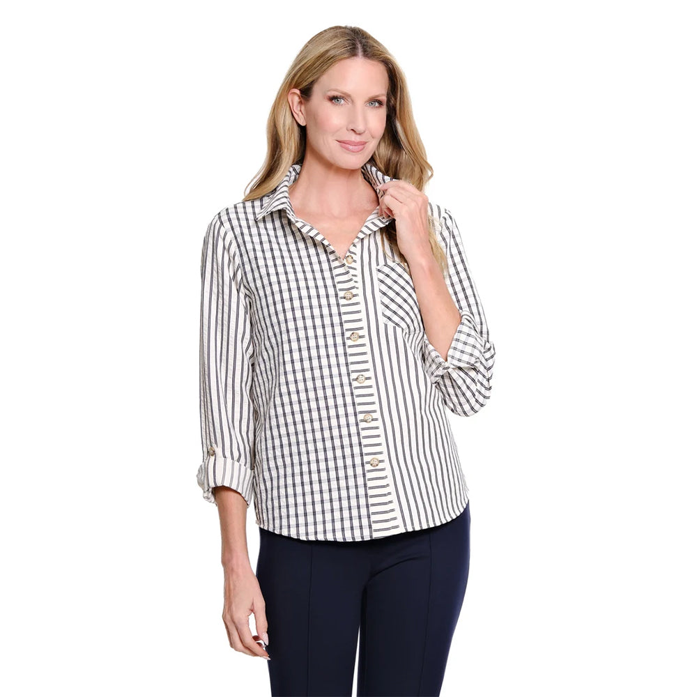 A woman modeling a long-sleeve button-up shirt with a black and white gingham pattern, paired with dark navy pants, against a solid white background.