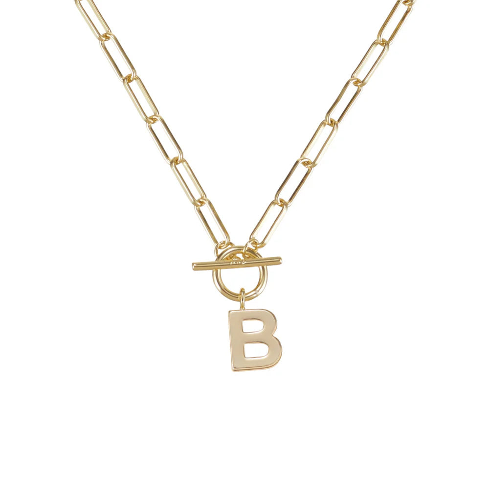Gold necklace with a toggle clasp and 'B' pendant on a white background