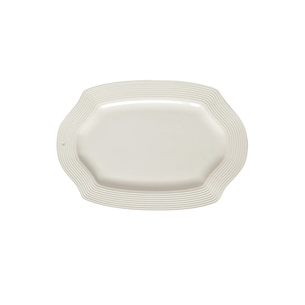 White ceramic platter with wavy edge on a white background