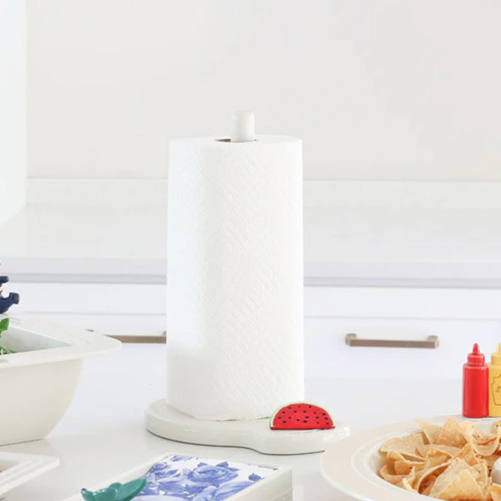 White paper towel holder with a red watermelon-shaped item on a kitchen counter.